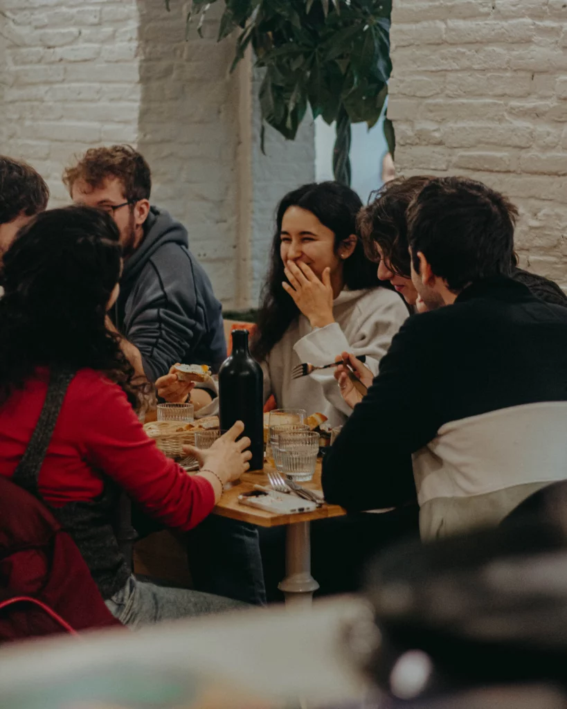 un groupe d'ami.es déjeune dans un coffee shop le midi à Toulouse et sourit