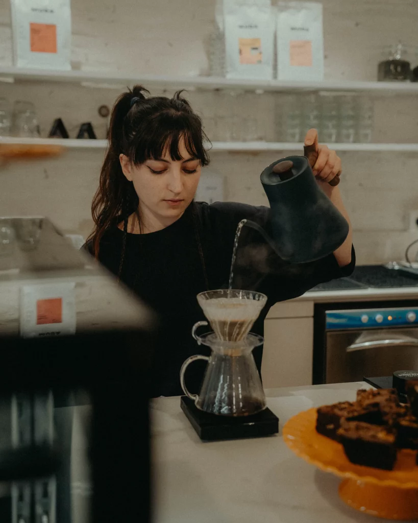 une barista réalise une infusion de café appelée V60 dans un coffee shop à Toulouse