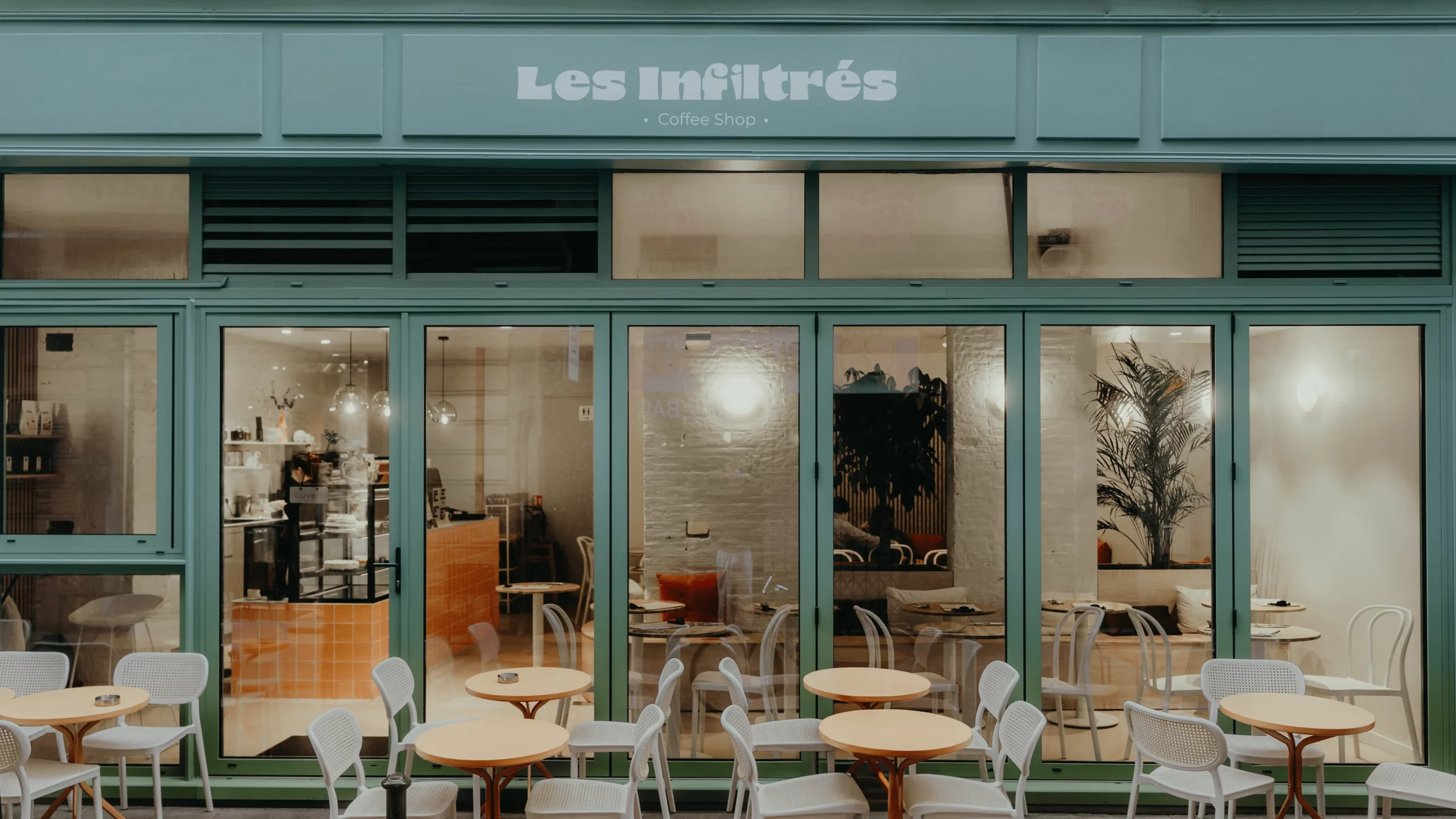 une façade de coffee shop à Toulouse avec une grande baie vitrée et une terrasse
