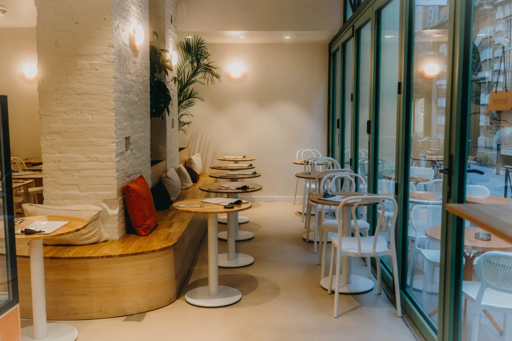 une salle de coffee shop à Toulouse avec une banquette de chêne brut et une grande baie vitrée