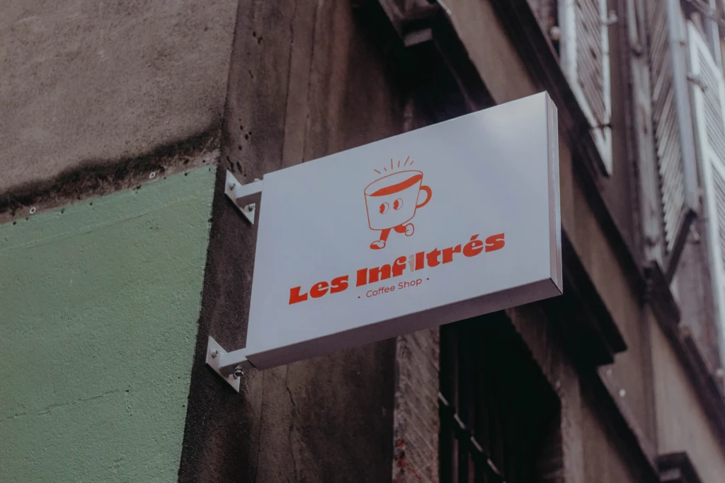 une enseigne de coffee shop à Toulouse qui représente une tasse orange avec des yeux qui court