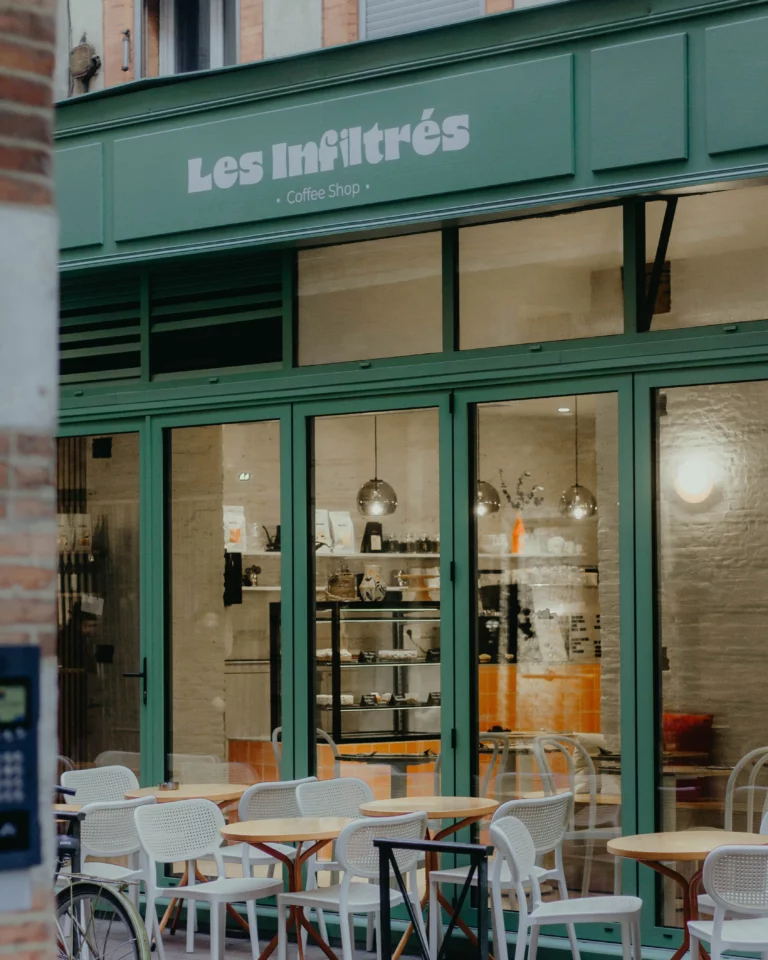 la façade d'un coffee shop à Toulouse avec une baie vitrée et une terrasse extérieure